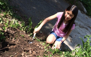 Girl taking soil samples from Indianapolis neighborhoods with potential contaminants.